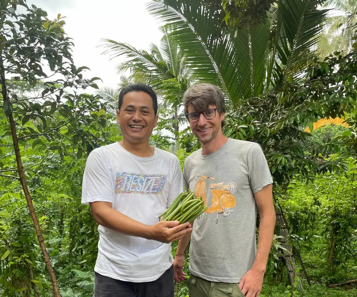 IKANI-Gründer Jonas mit Vanillepartner auf Bali und grünen Vanilleschoten